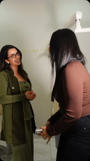 Dra. Priscilla Gaby conversando com uma paciente no consultório